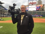 Scott Changnon standing on the field, camera in hand, at the World Series